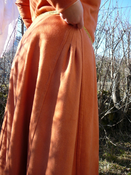 Vue de côté de la robe : le godet et ses plis se déroulent sur les hanches