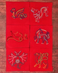 6 carrés de lin rouge brodés au point de chaînette en laine colorée représentants des animaux médiévaux : un dragon, un lapin, une licorne, un renard, une chauve-souris et un griffon