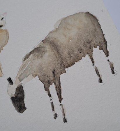 Photo d'un carnet avec un mouton en train de paître peint à l'aquarelle.