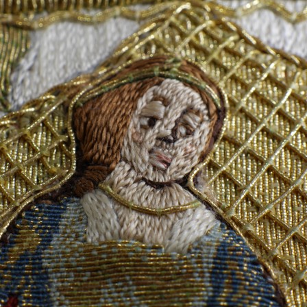Gros plan sur la broderie de la tête de Judith.