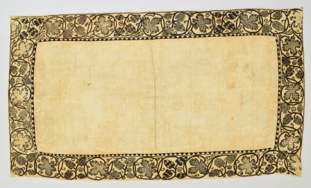 Broderie noire sur toile écrue : la broderie est une frise végétale sur le contour d'une pièce rectangulaire. Le remplissage des feuilles et fleurs est brodé avec des points géométriques