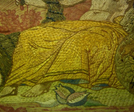 Détail de la broderie sur le drapé qui recouvre les jambes du personnage. Brodé en Jaune.